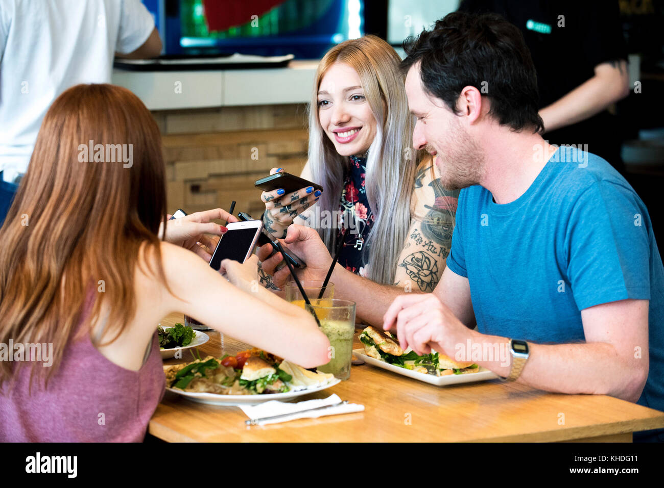 Friends chatting and using smart phones Stock Photo