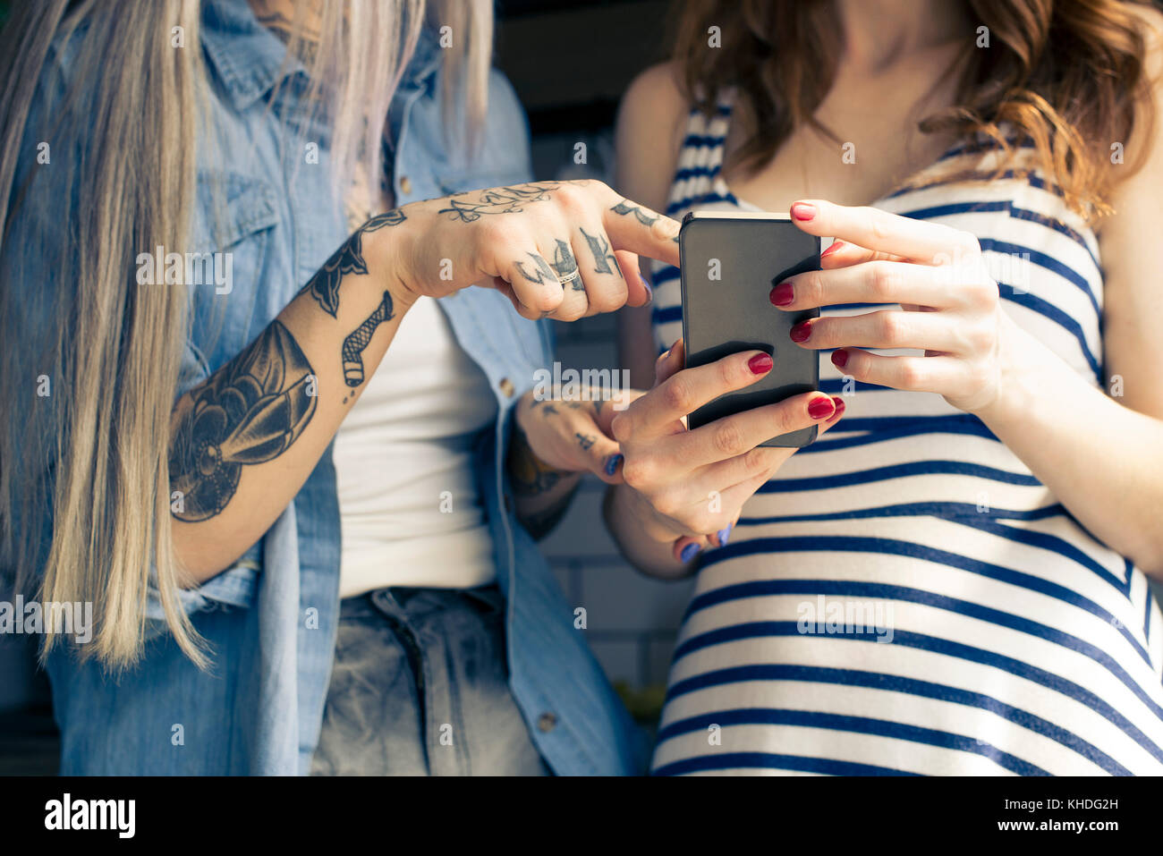 Women using smartphone together, cropped Stock Photo