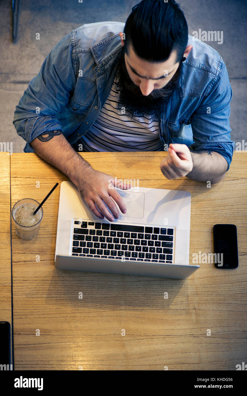 Man using laptop computer in cafe Stock Photo - Alamy