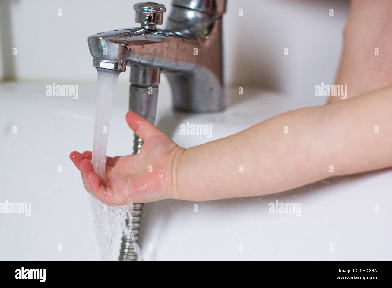 Child's hand testing bath water temperature Stock Photo