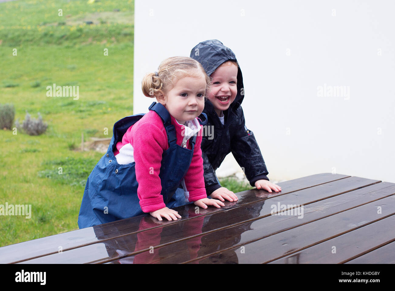 Children climbing on wet picnic table Stock Photo
