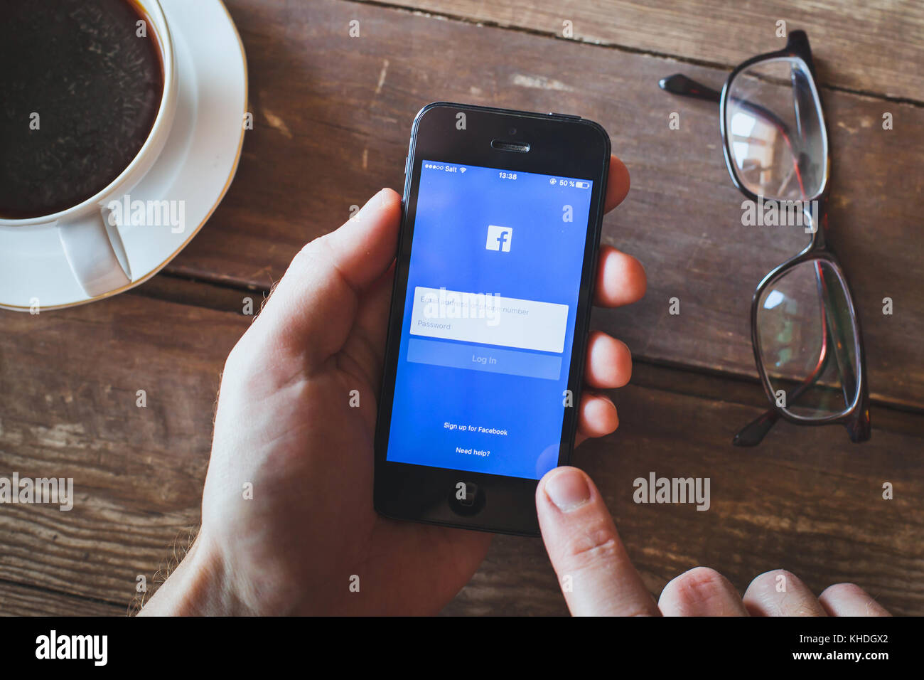 ANZERE, SWITZERLAND - SEPTEMBER 22 2017: Person using Facebook social network on the screen of smartphone iPhone, login page of app Stock Photo