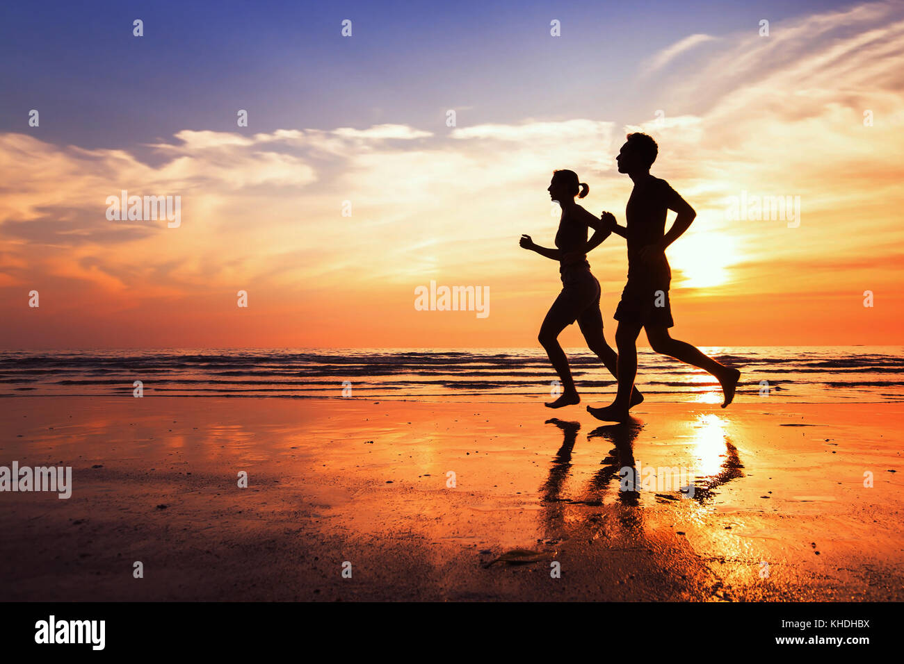 running background, sport and workout, silhouettes of people jogging at sunset beach Stock Photo