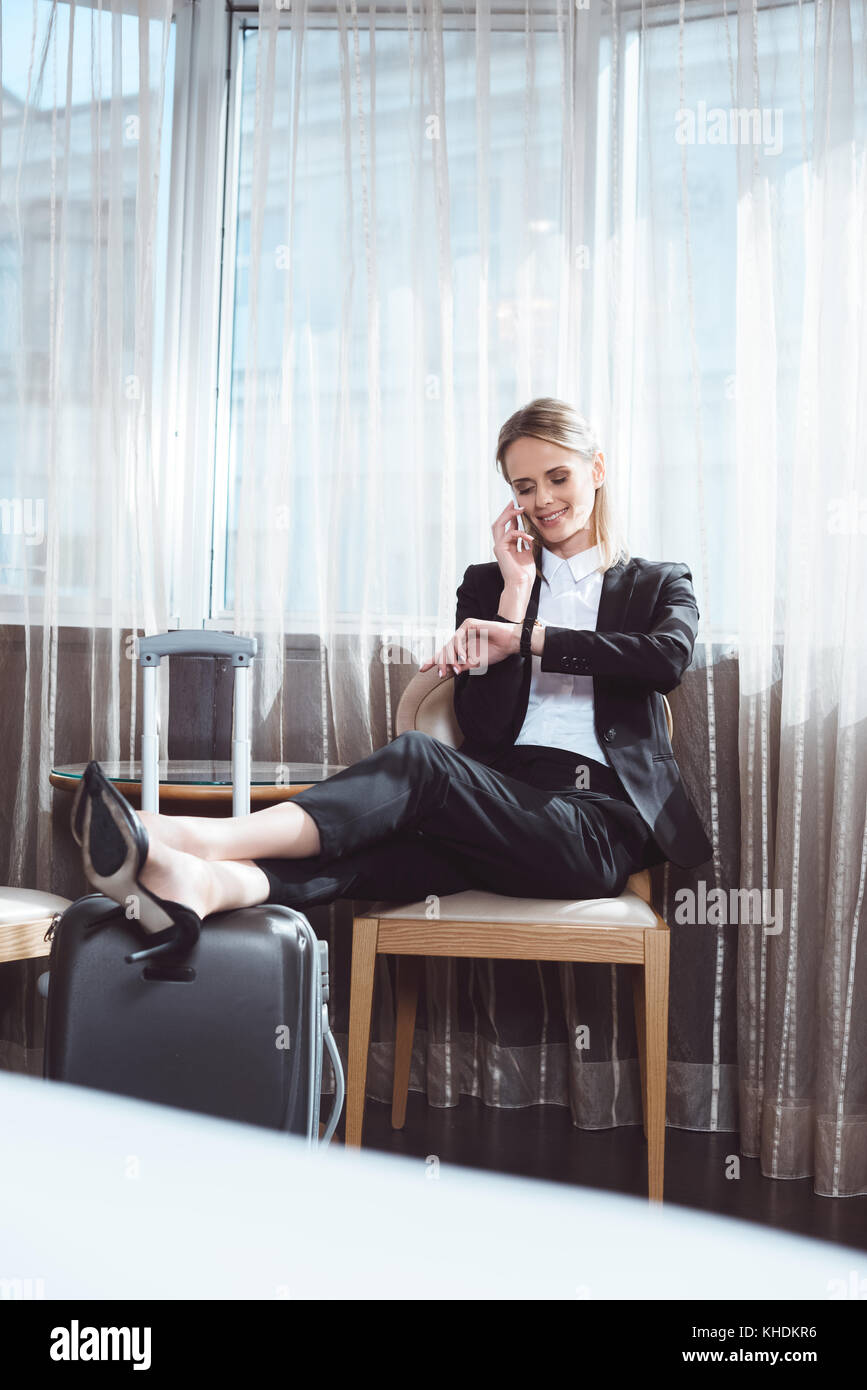 businesswoman using smartphone in hotel room Stock Photo
