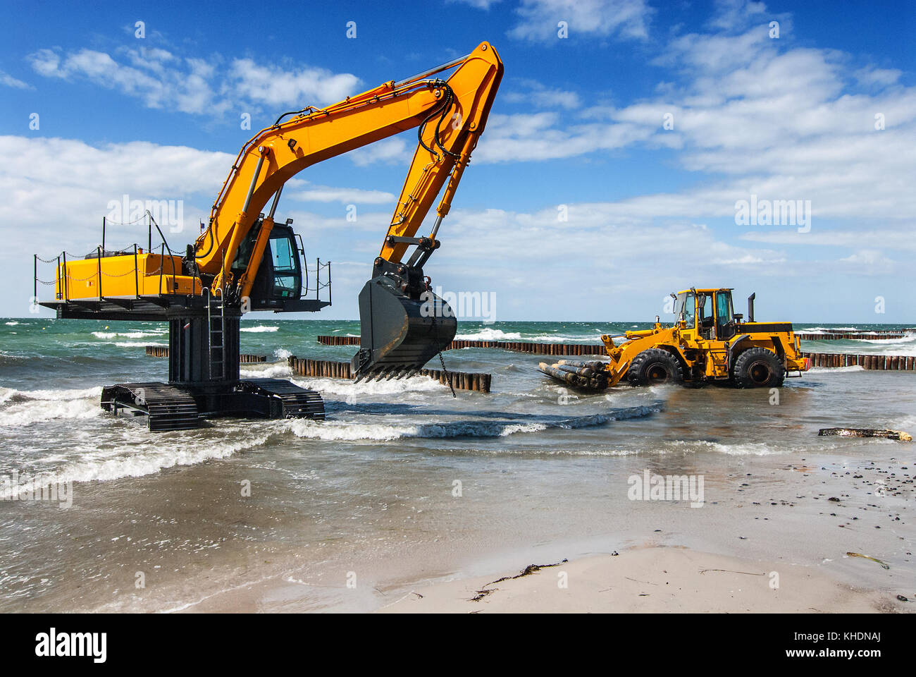 excavator and bulldozer on the beach, building groynes Stock Photo Alamy