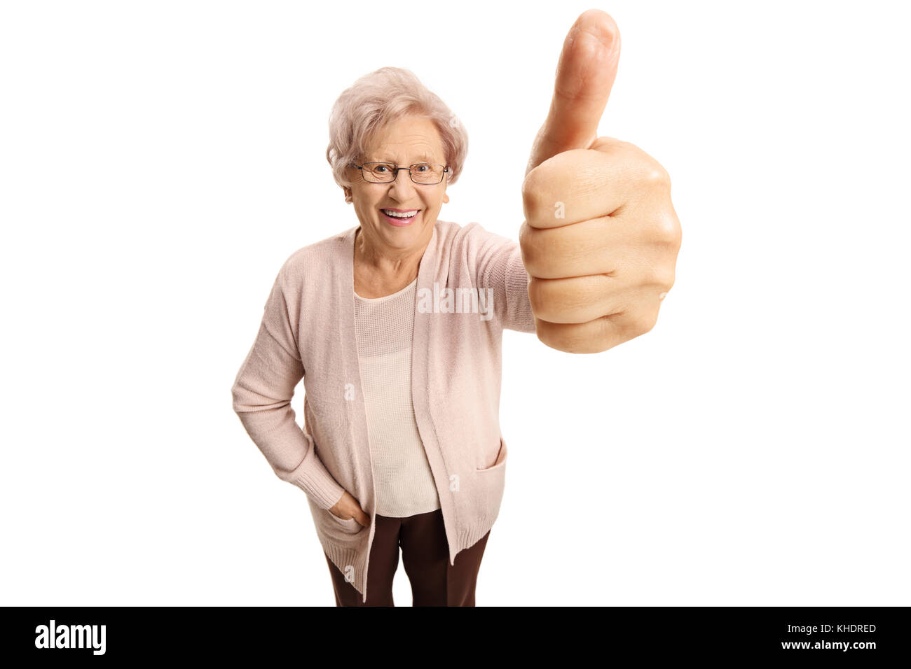Elderly woman making a thumb up sign and smiling isolated on white background Stock Photo