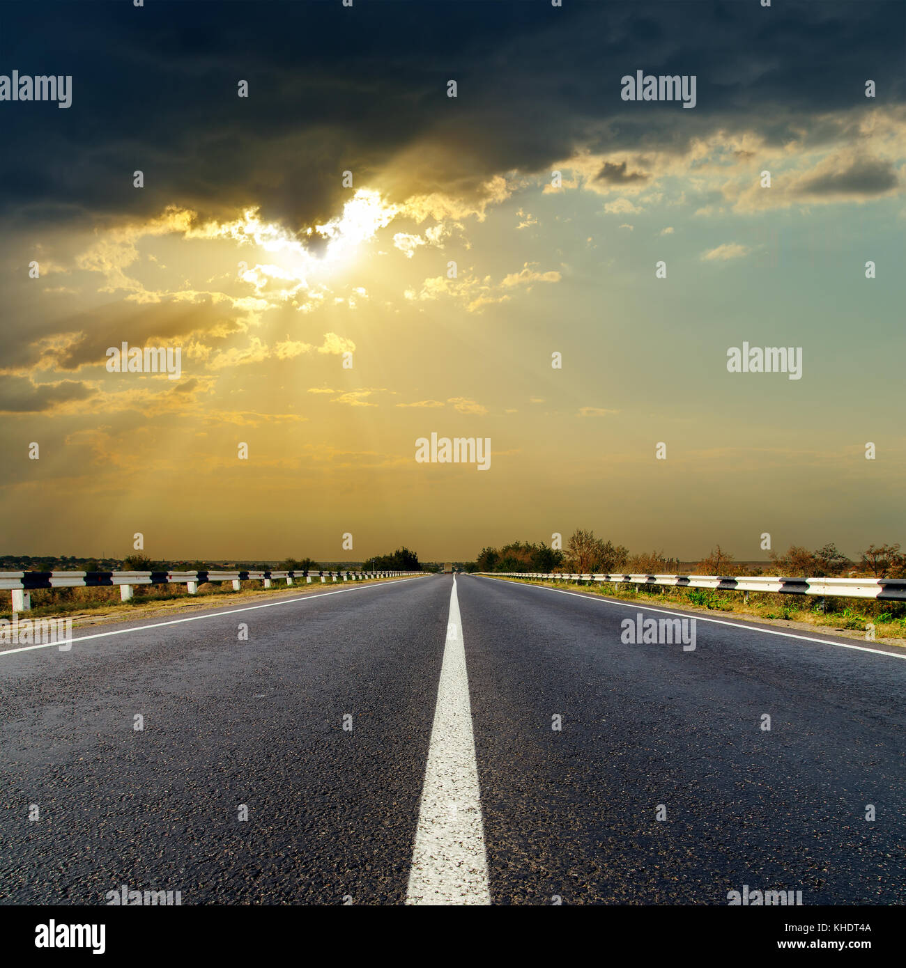 dark low clouds over asphalt road on sunset Stock Photo - Alamy
