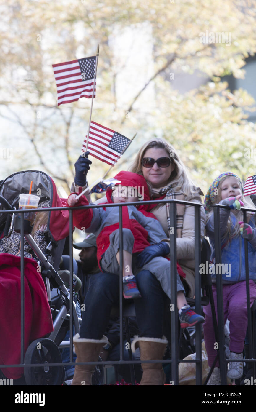 Moms and children show their patriotism on a military float in the Veterans Day Parade on 5th Avenue in New York City. Stock Photo
