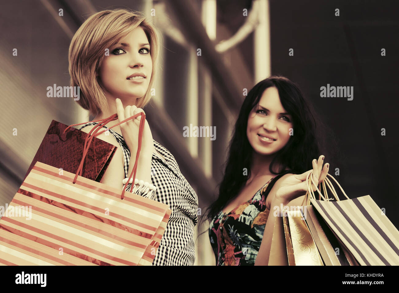 Two young fashion women with shopping bags in the mall Stock Photo - Alamy