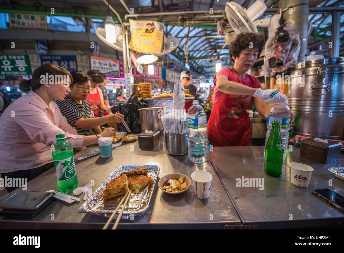 Eating 'bindaeduk' at a food stall in Kwangjang Market in Seoul 2017. Stock Photo
