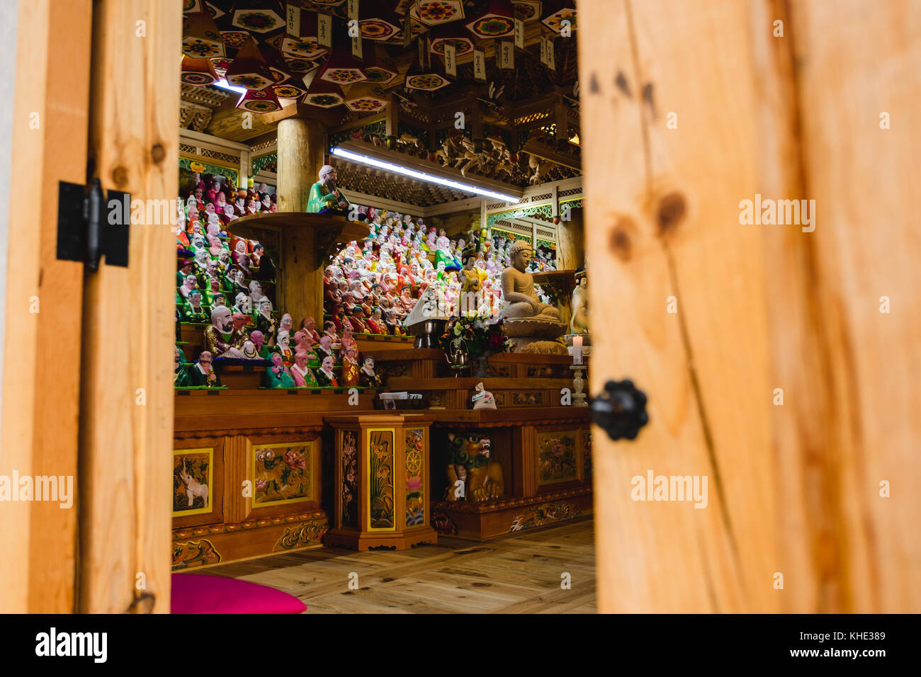 A view inside a temple building showing a collection of statues and figurines. Seoul, South Korea. Stock Photo