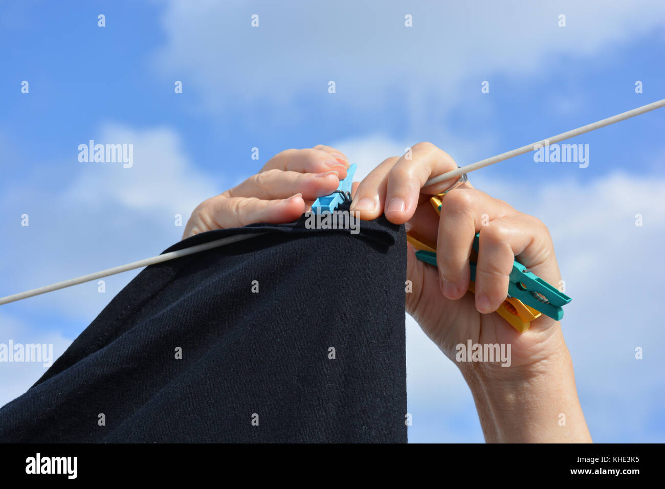 Laundry day. Hanging out the washing on a clothes line outdoors. Stock Photo