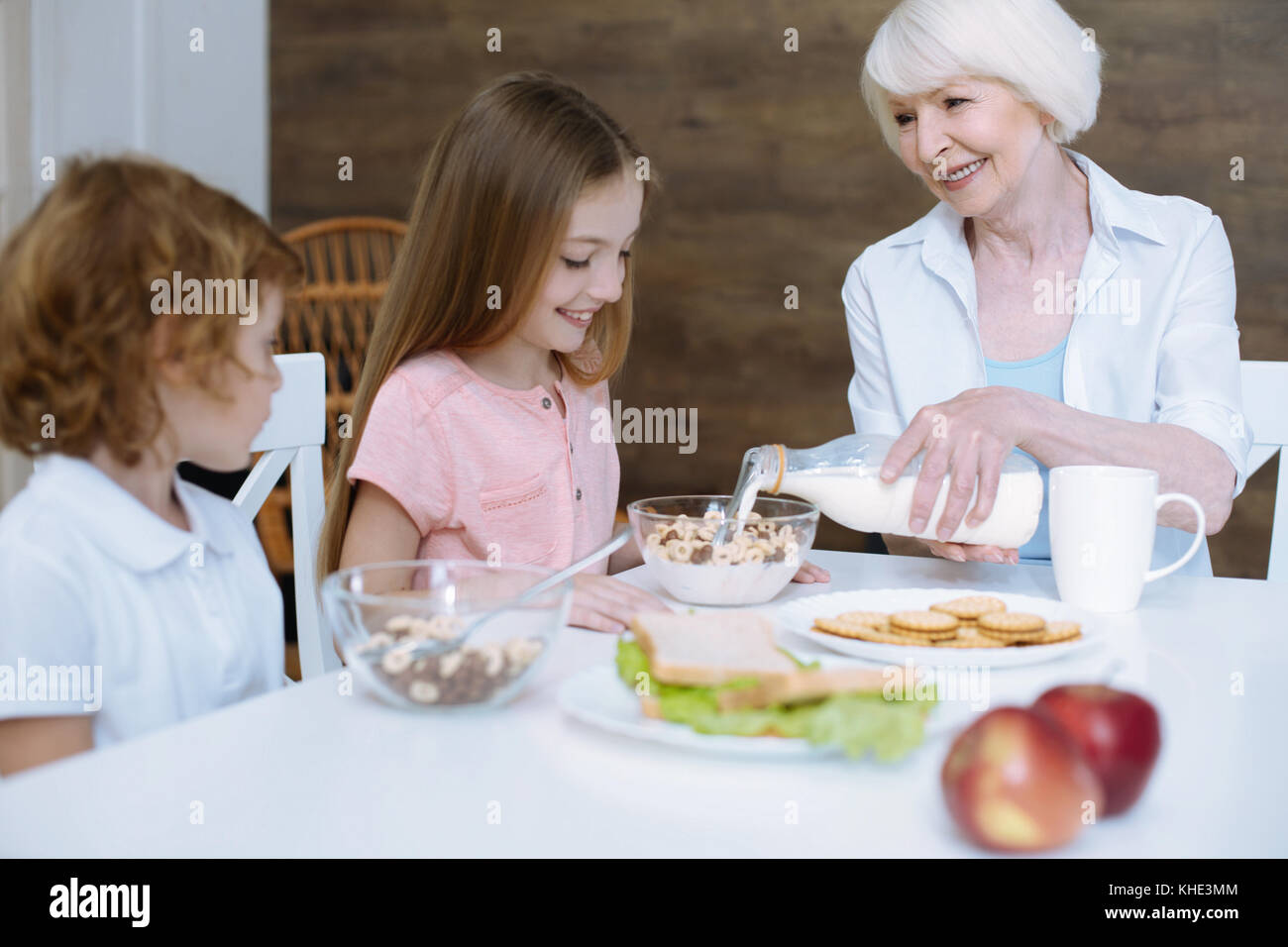 Loving granny pouring milk into a bowl Stock Photo Alamy