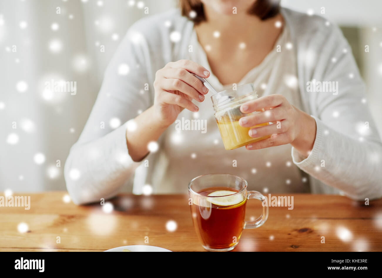 Close up of woman adding honey to tea with lemon stock photo alamy