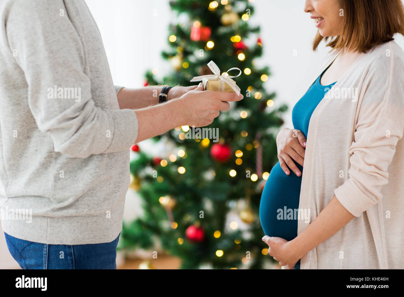 husband giving christmas present to pregnant wife Stock Photo - Alamy