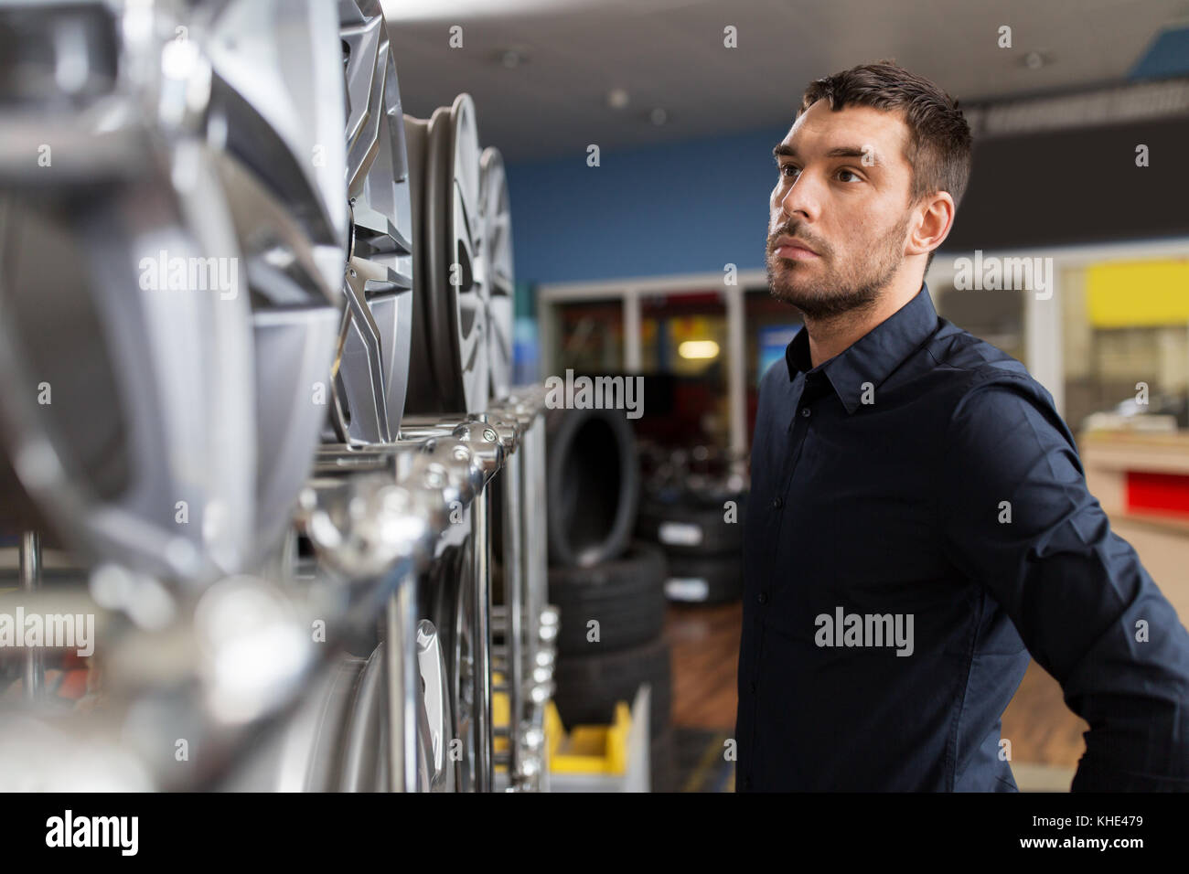 male customer choosing wheel rims at car service Stock Photo Alamy