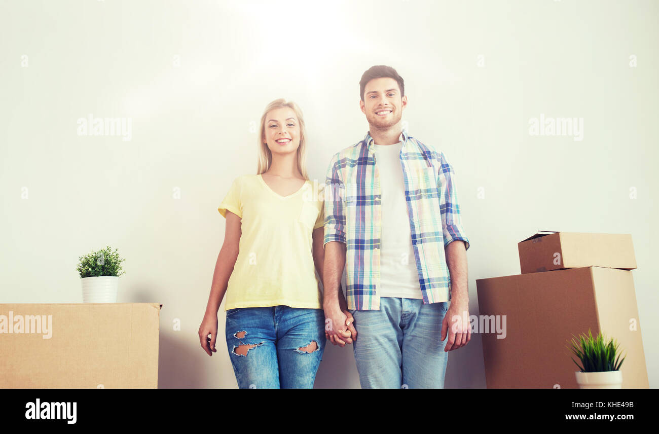 smiling couple with big boxes moving to new home Stock Photo - Alamy