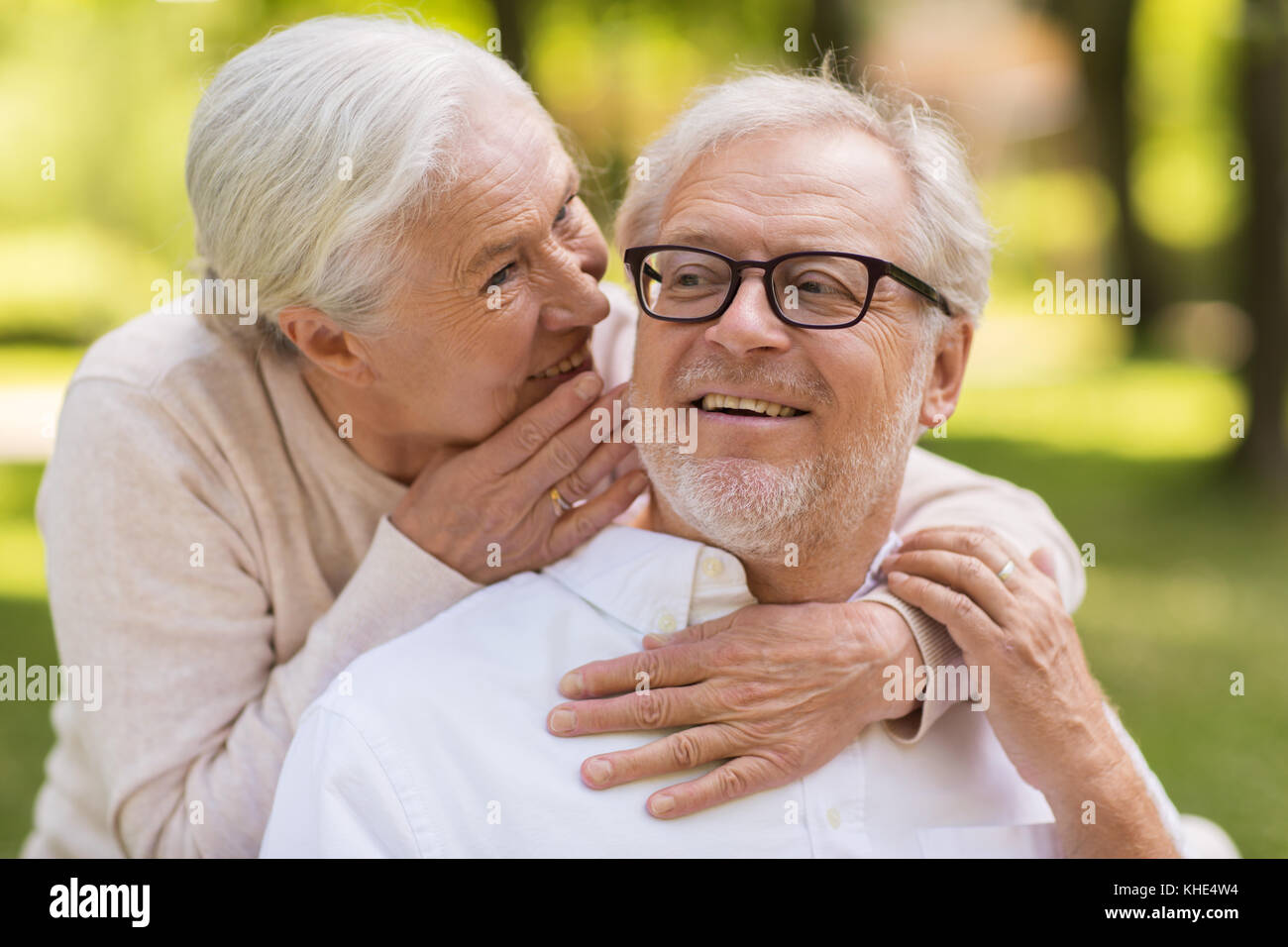 happy senior couple sitting on bench at park Stock Photo - Alamy