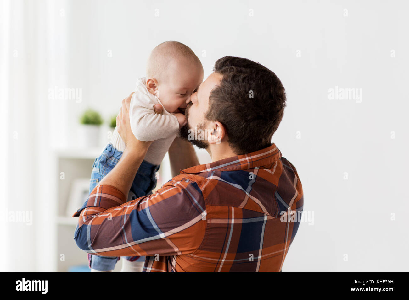 happy father kissing little baby boy at home Stock Photo