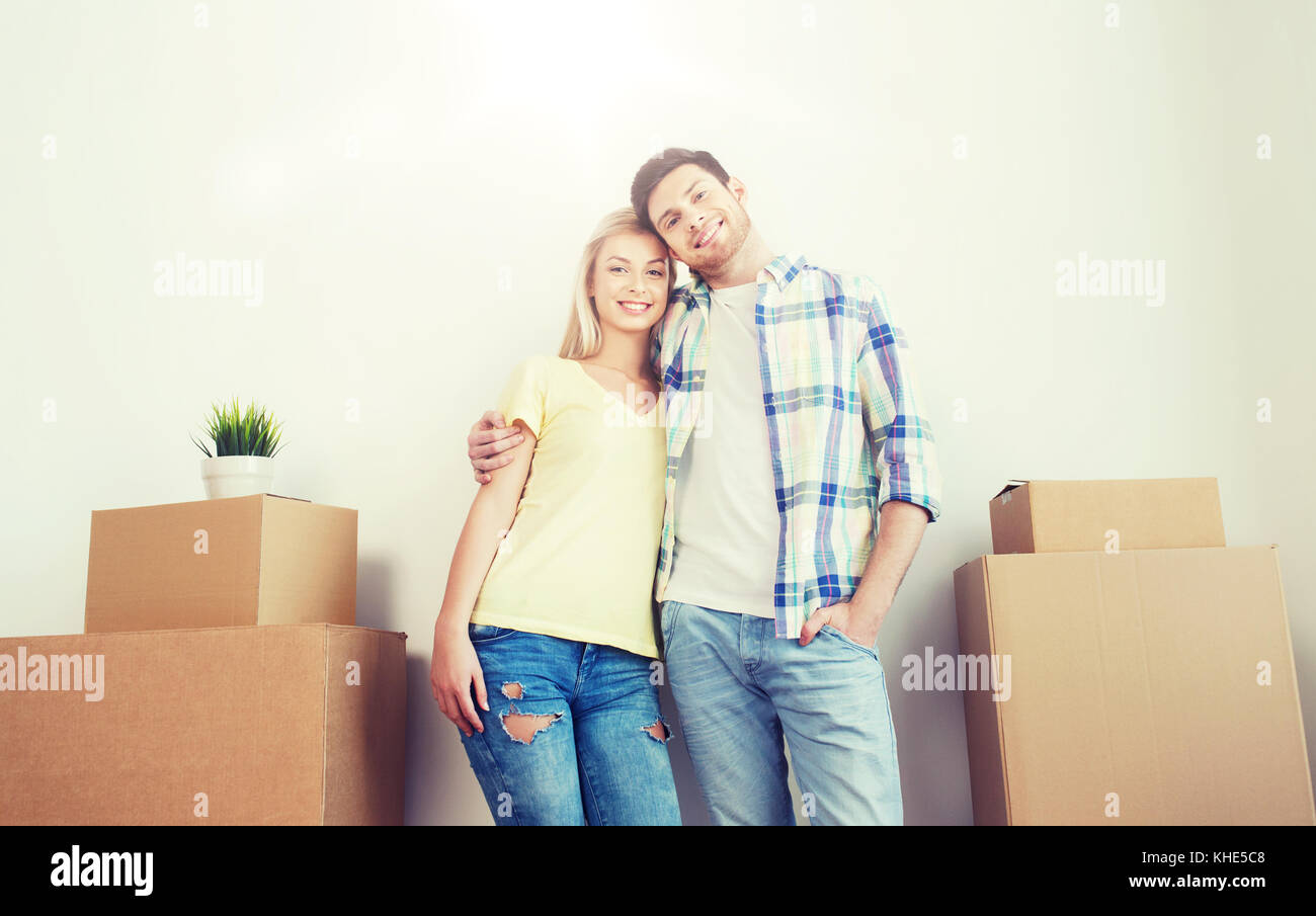smiling couple with big boxes moving to new home Stock Photo - Alamy