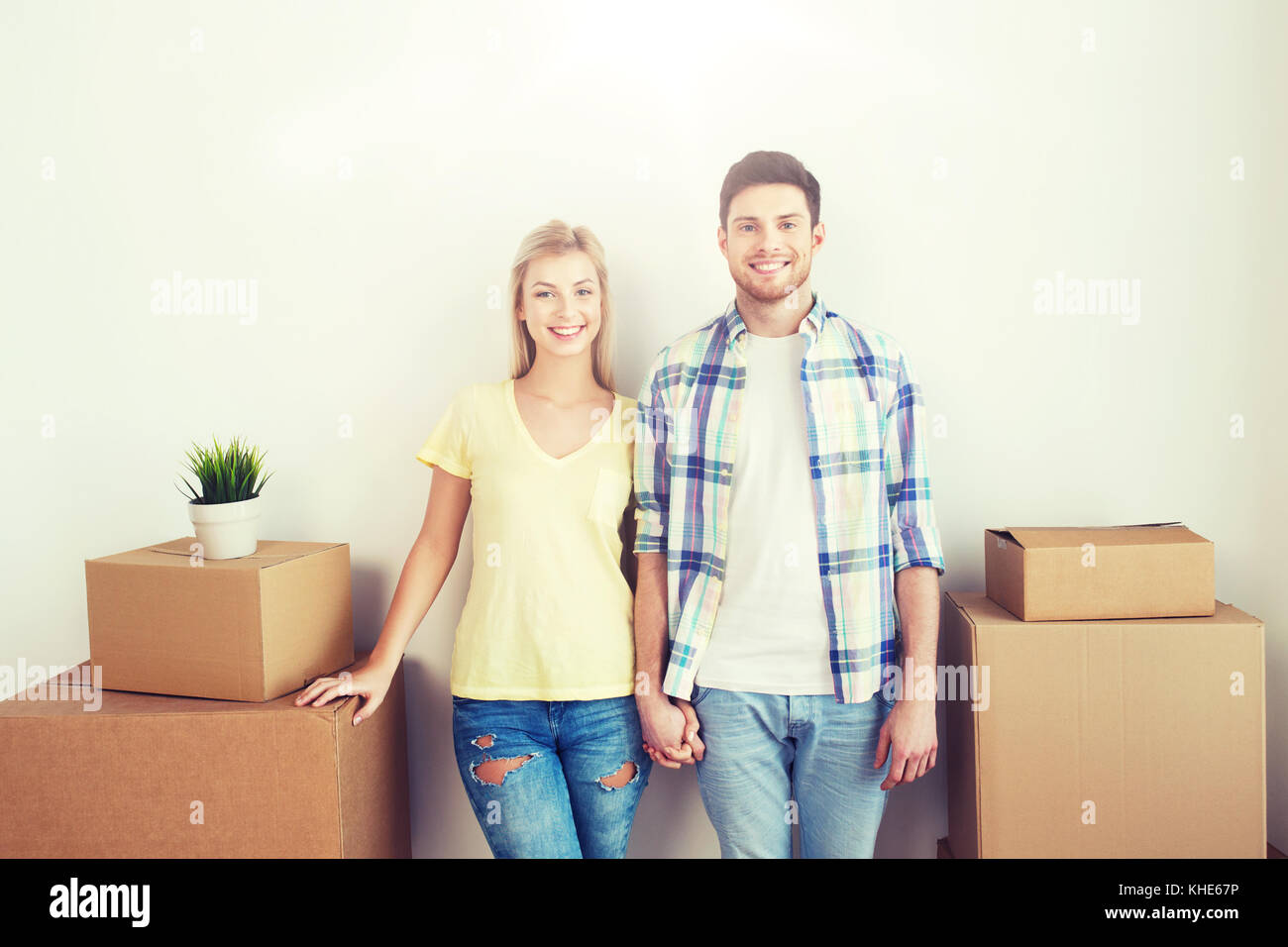 smiling couple with big boxes moving to new home Stock Photo - Alamy