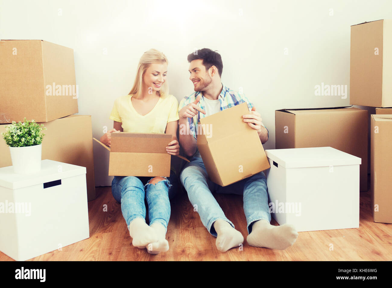 smiling couple with many boxes moving to new home Stock Photo - Alamy