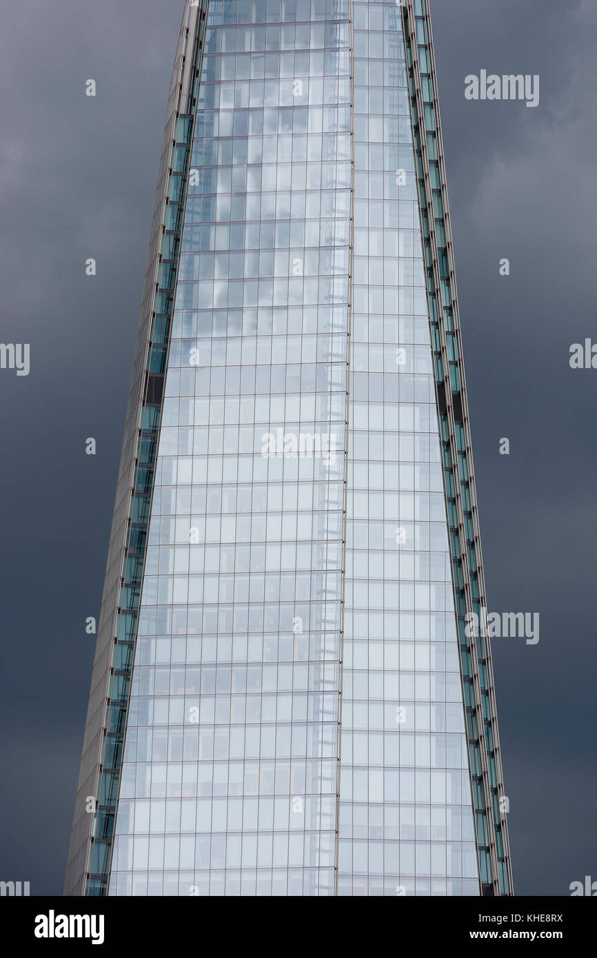 London, UK. Close up view of the windows near the top of The Shard against a dark blue overcast sky. Stock Photo