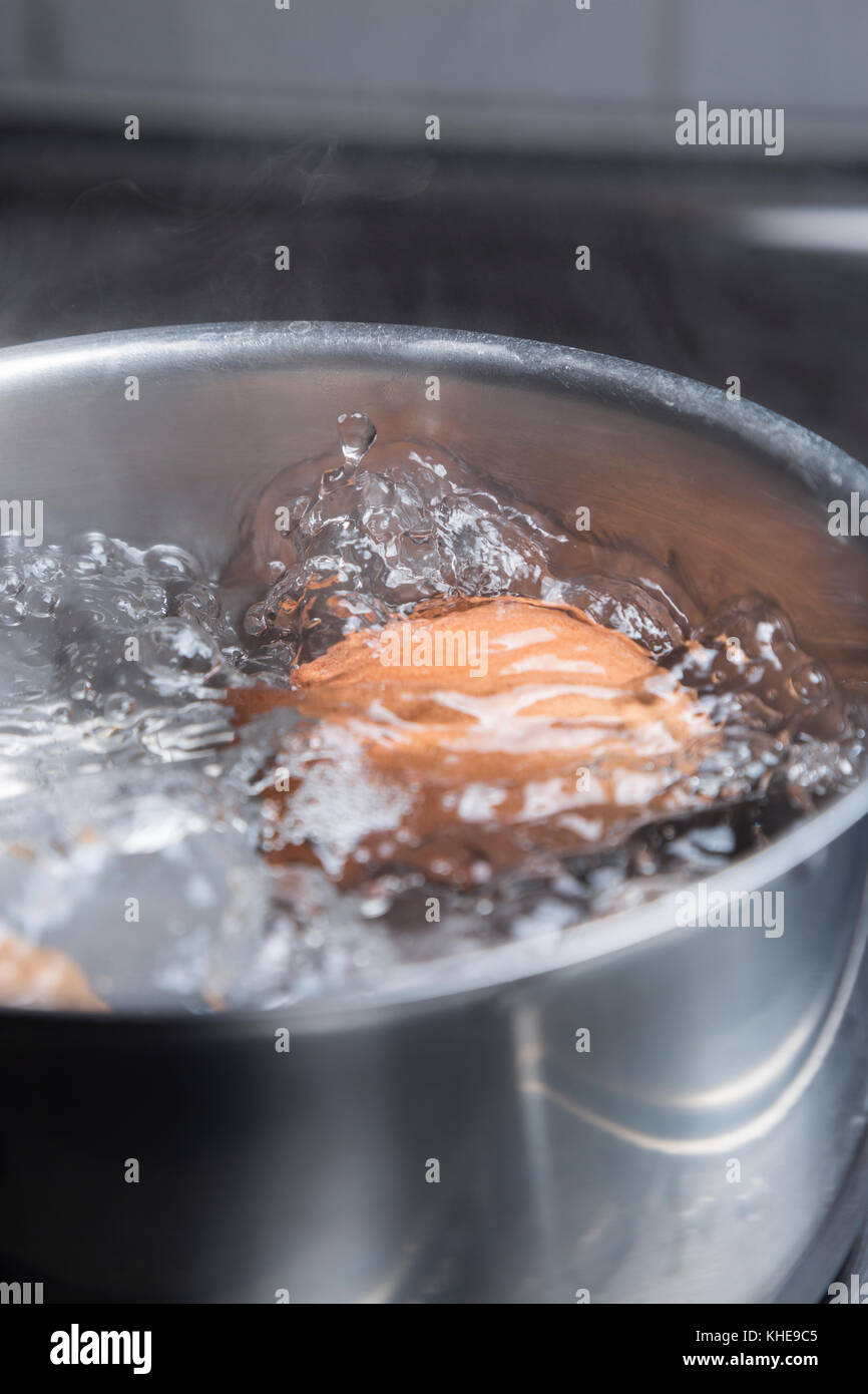 Eggs in boiling water in saucepan on electric hob Stock Photo Alamy