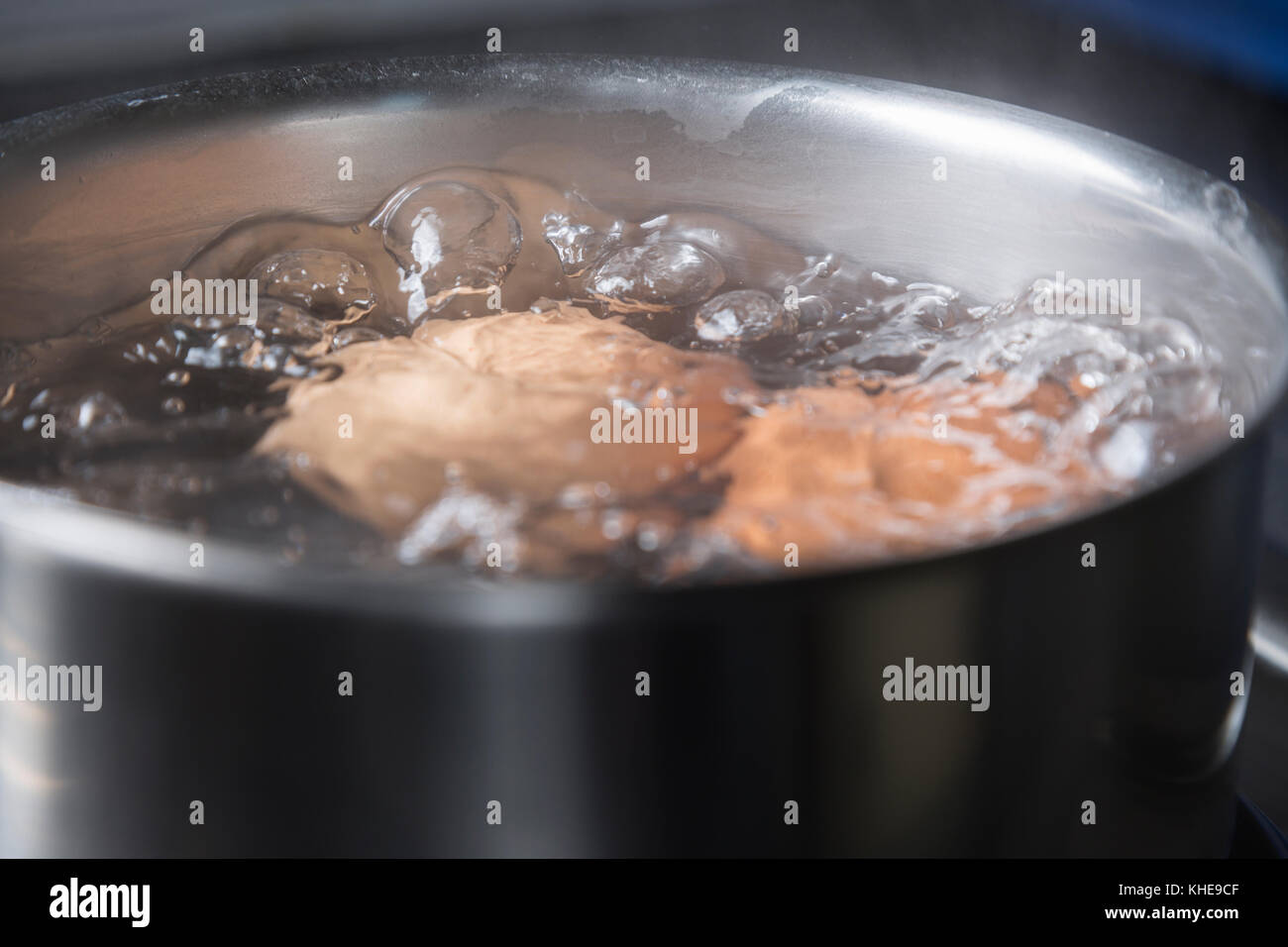 Eggs in boiling water in saucepan on electric hob Stock Photo Alamy