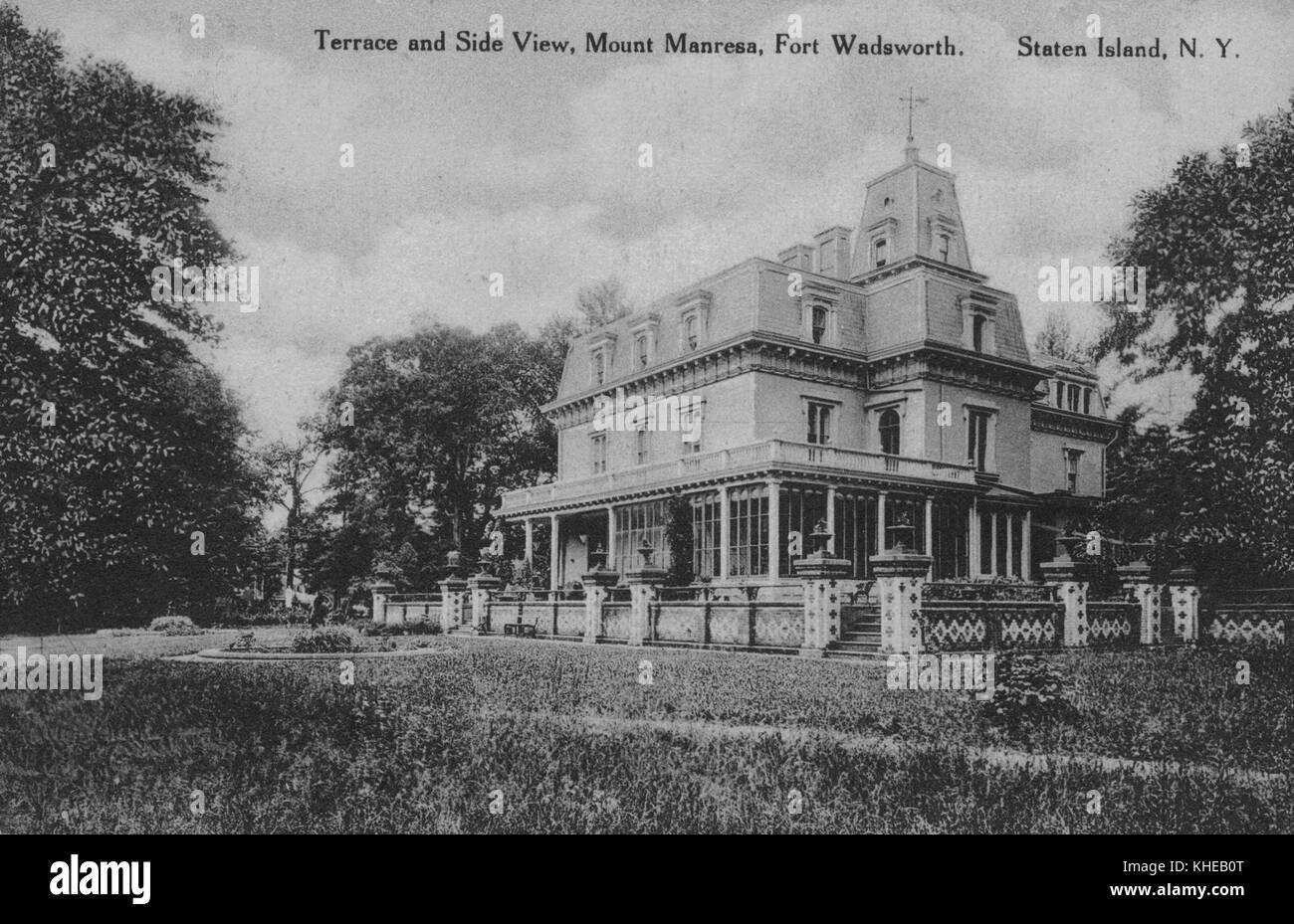 An old postcard picture of Mount Manresa, corner view showing the two sides of the whole building with its open terrace, low decorative fence, and a grassy lawn in the foreground, Fort Wadsworth, Staten Island, New York, 1900. From the New York Public Library. Stock Photo