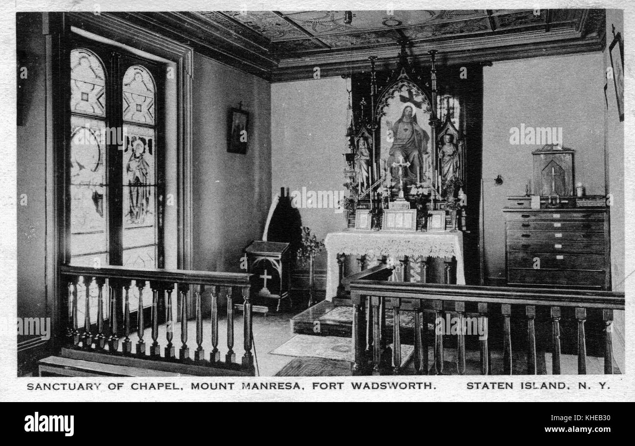 An old postcard picture of the sanctuary inside the chapel of Mount Manresa, an angular view showing images mounted on an altar, a stained glass window on the left side, and short wooden railings bordering the front, Fort Wadsworth, Staten Island, New York, 1900. From the New York Public Library. Stock Photo