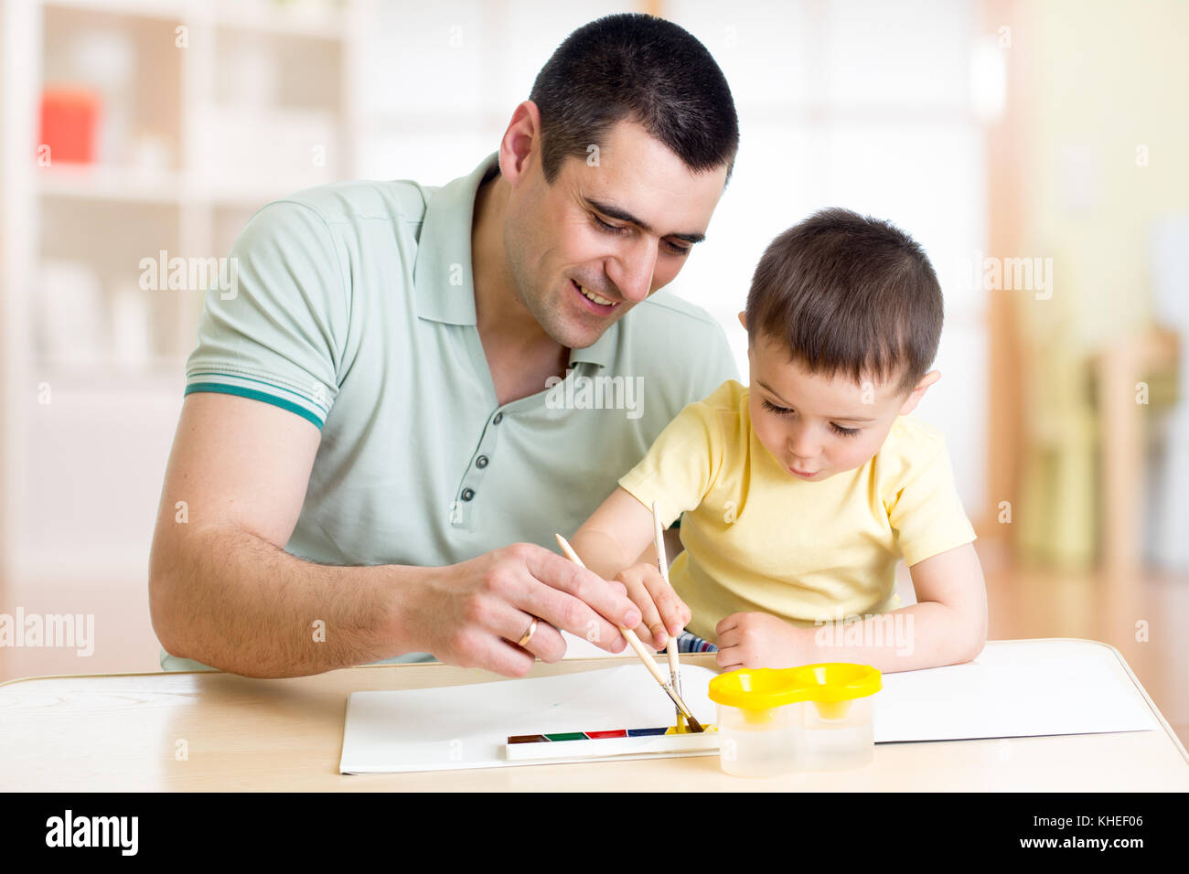 Dad and kid son have a fun painting with watercolor paints Stock Photo