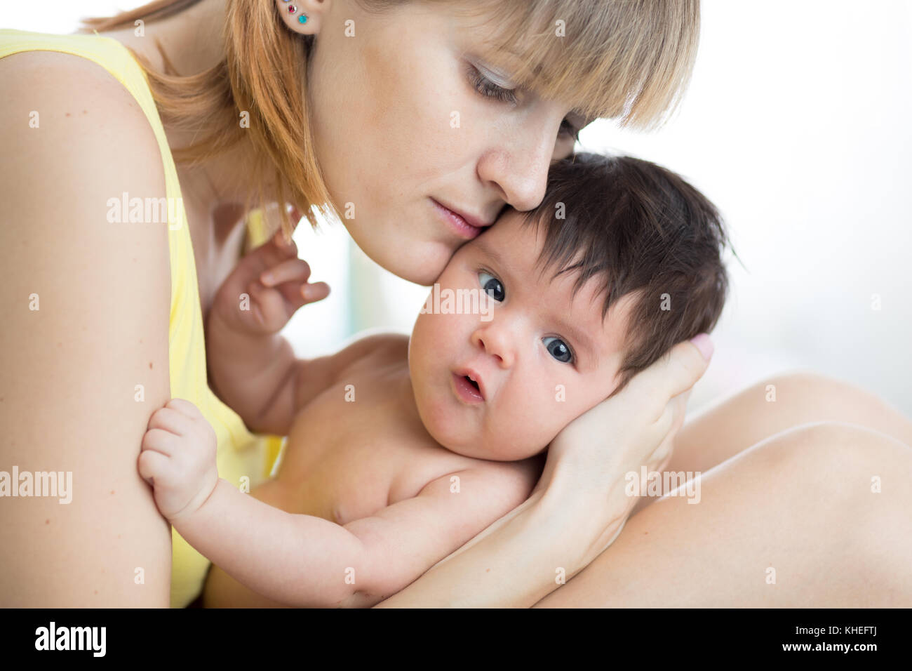 Happy mother with newborn baby at home. Family, child and parenthood concept. Stock Photo