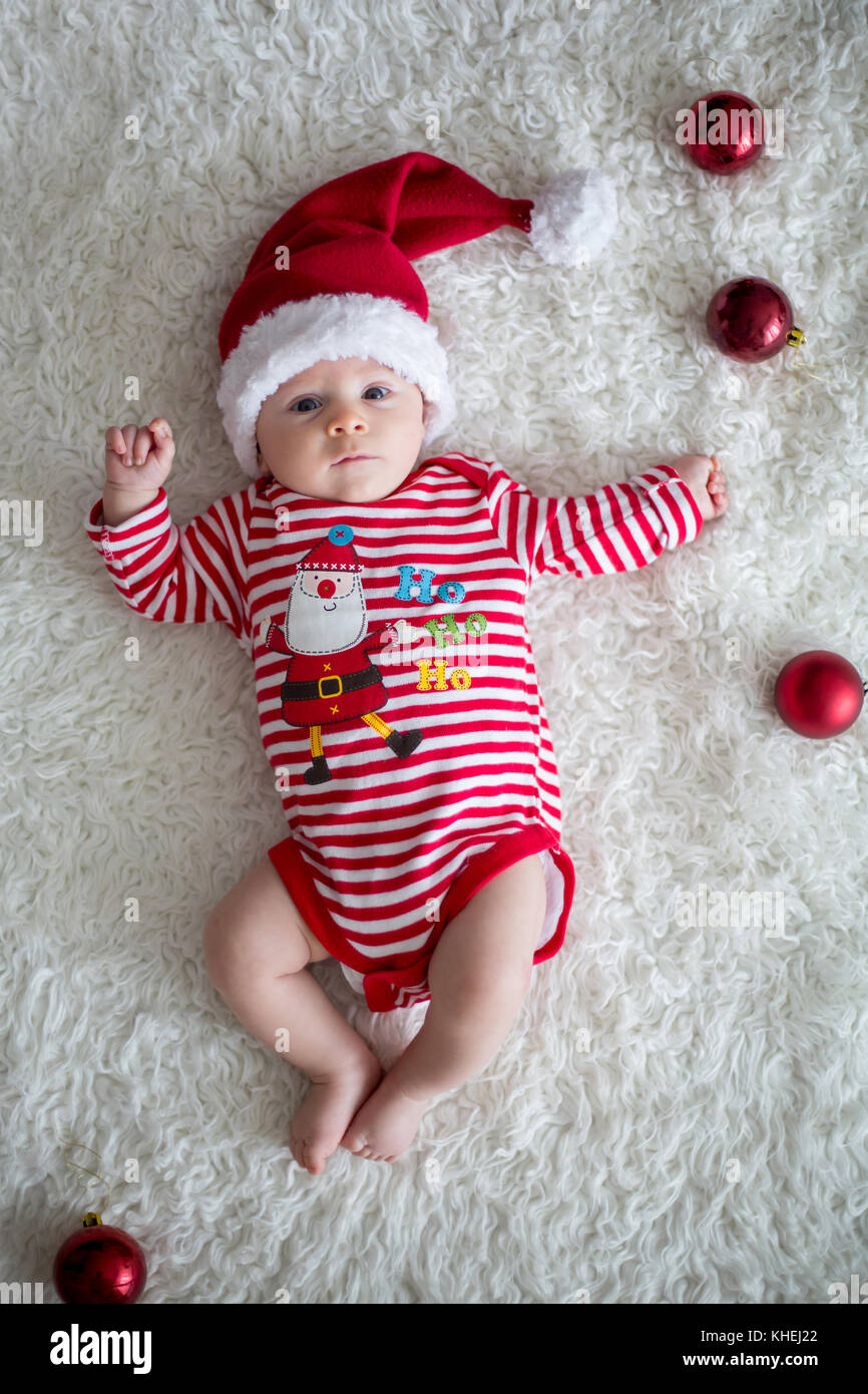 Christmas portrait of cute little newborn baby boy, dressed in ...