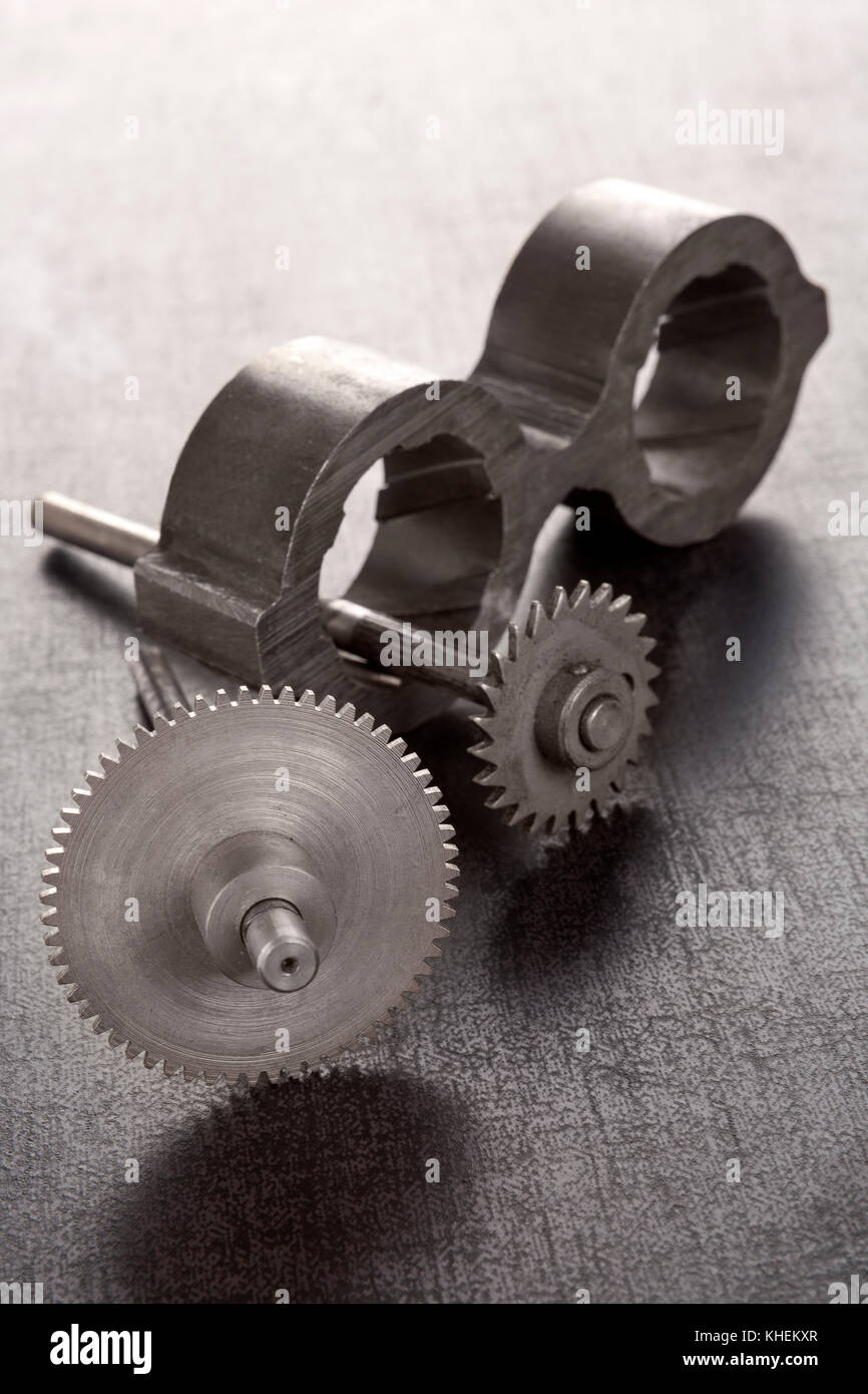 Cogwheels and mechanical component on concrete. Industrial parts. Heavy industry concept. Stock Photo