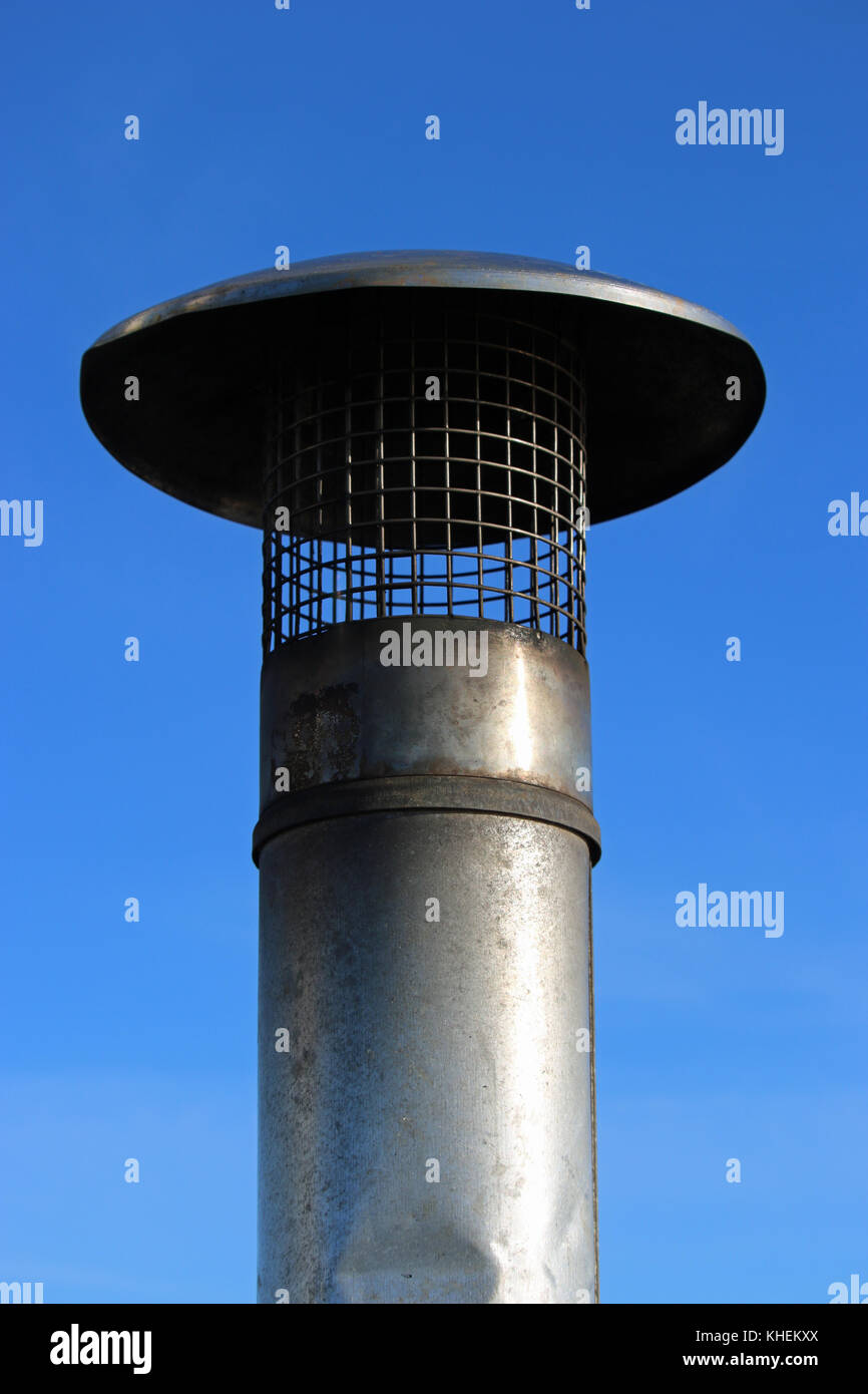 Metal chimney from a fire on a boat with a background of deep blue sky ...