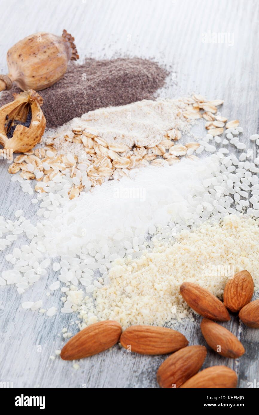 Various types of flours. Almond, rice, oat and poppyhead flour on wooden table. Stock Photo