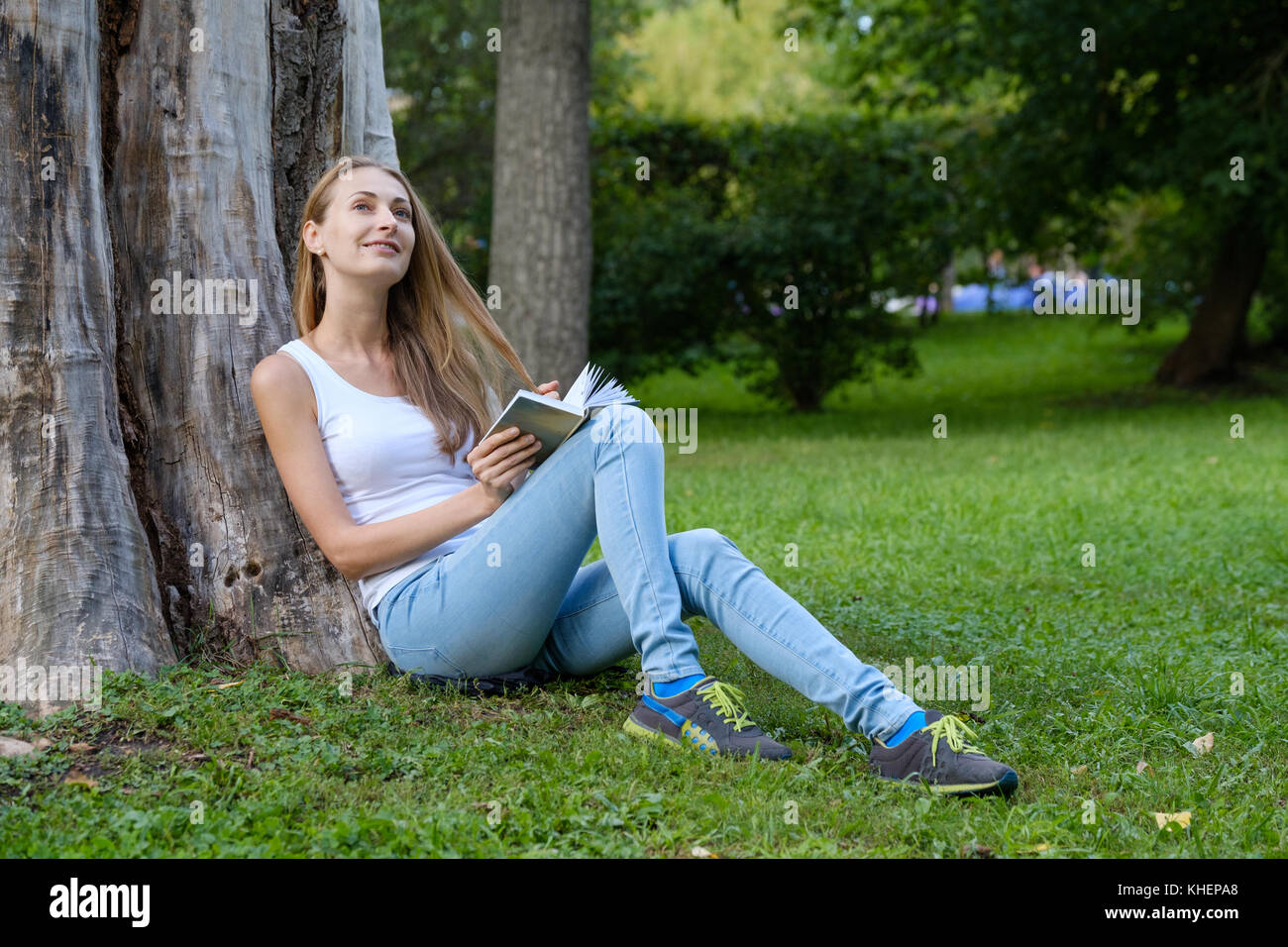 Young woman reading a book in the park Stock Photo - Alamy