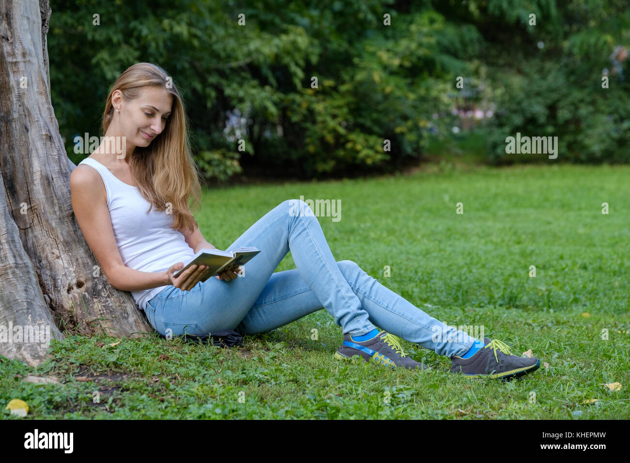 Young woman reading a book in the park Stock Photo - Alamy