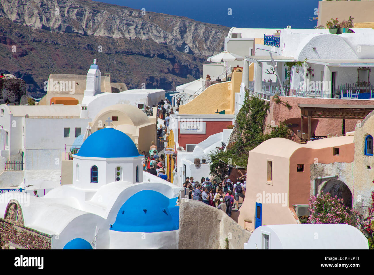 Flow of tourists walks a narrow alley, Oia, Santorin island, Cyclades, Aegean, Greece Stock Photo