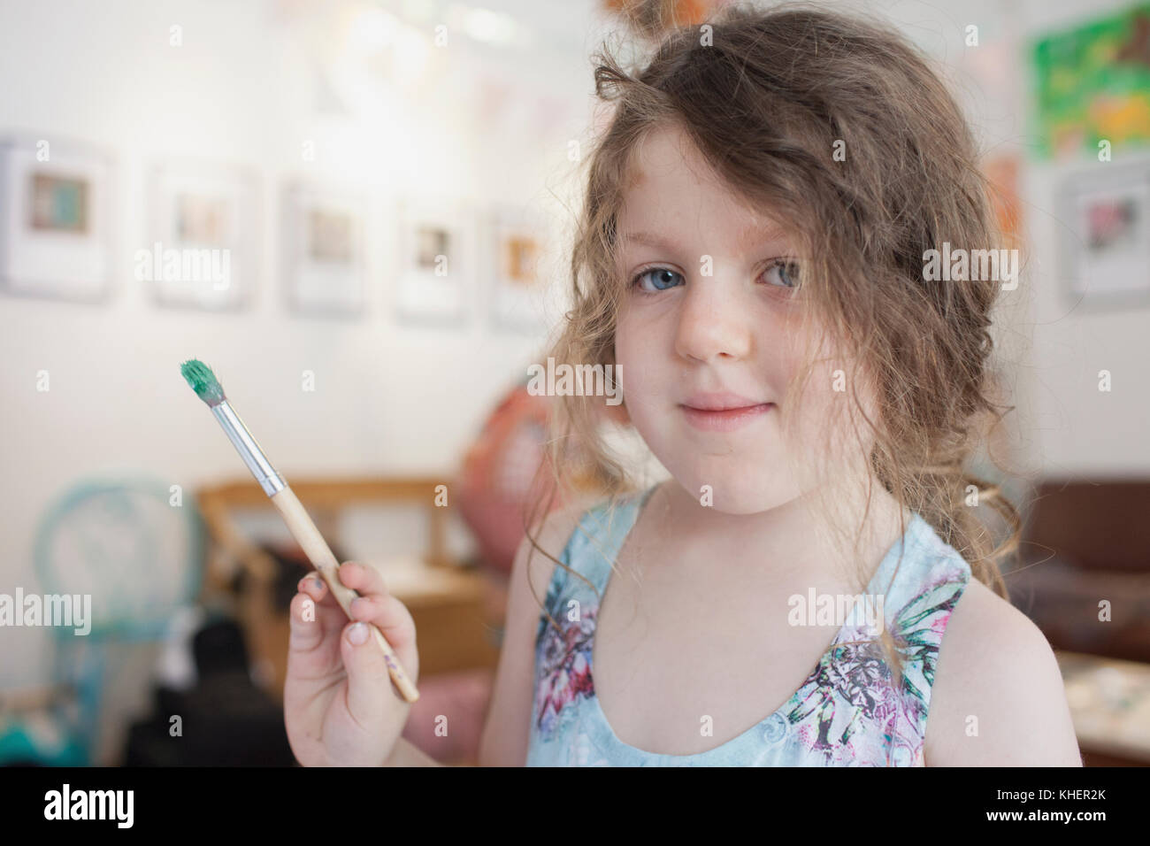 A girl holding a paintbrush Stock Photo Alamy