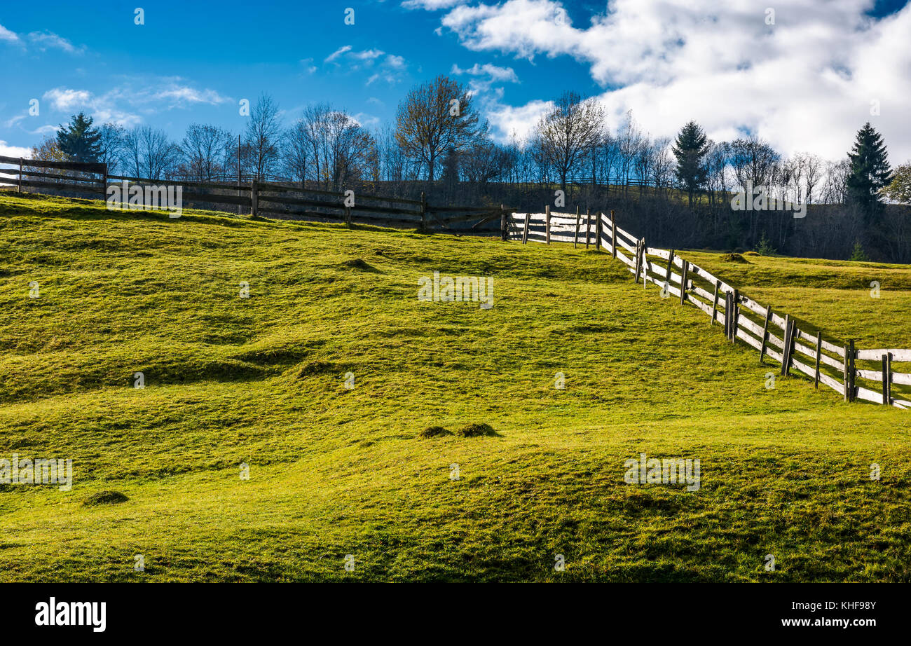 wooden fence on grassy hillside in autumn. wonderful rural scenery in ...