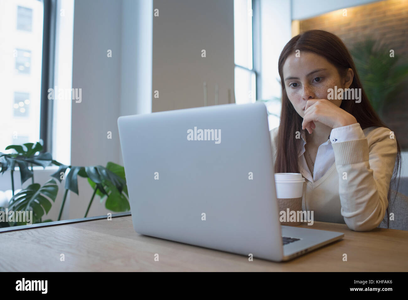 Young woman working on her laptop at office desk Stock Photo - Alamy