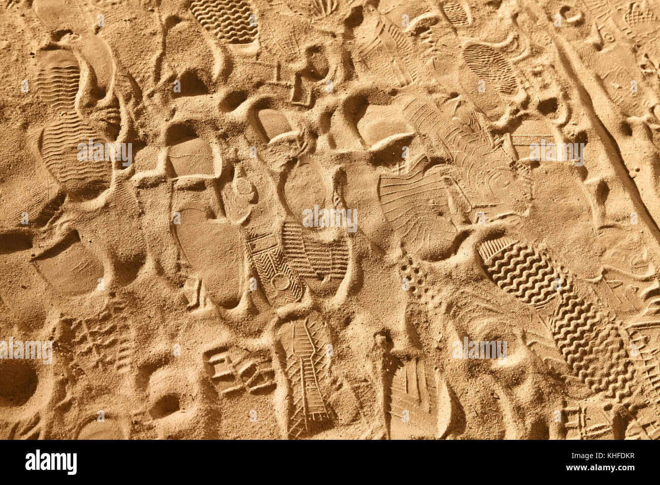 prints from various footwear on sand, background Stock Photo