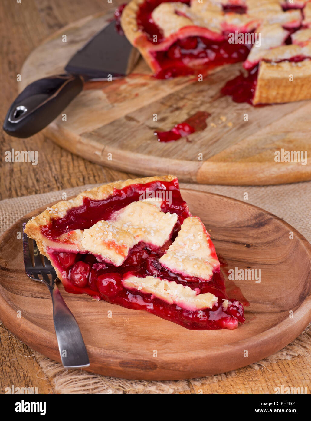 Slice of cherry pie on a wooden plate Stock Photo
