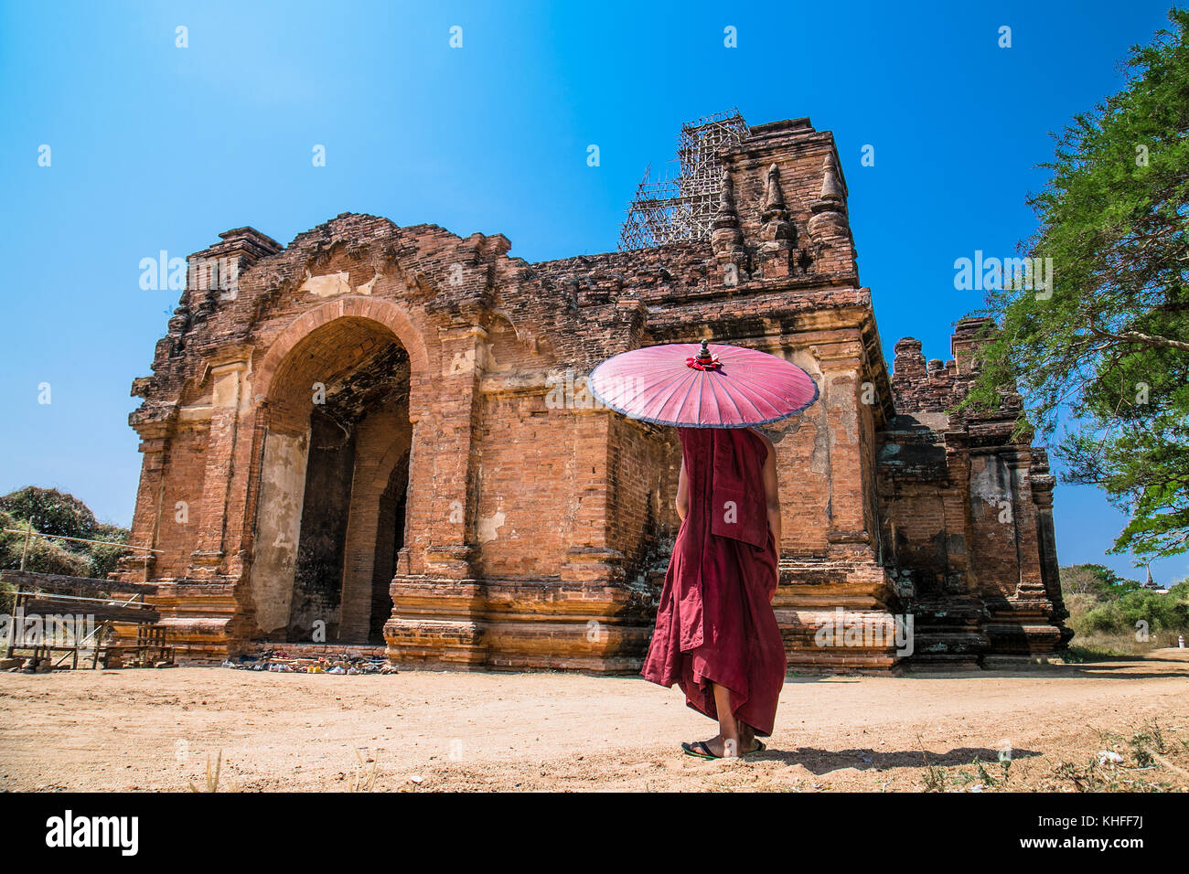 Buddhist with umbrella in front of Pahto Thamya Temple, Old Bagan, Myanmar.(Burma Stock Photo