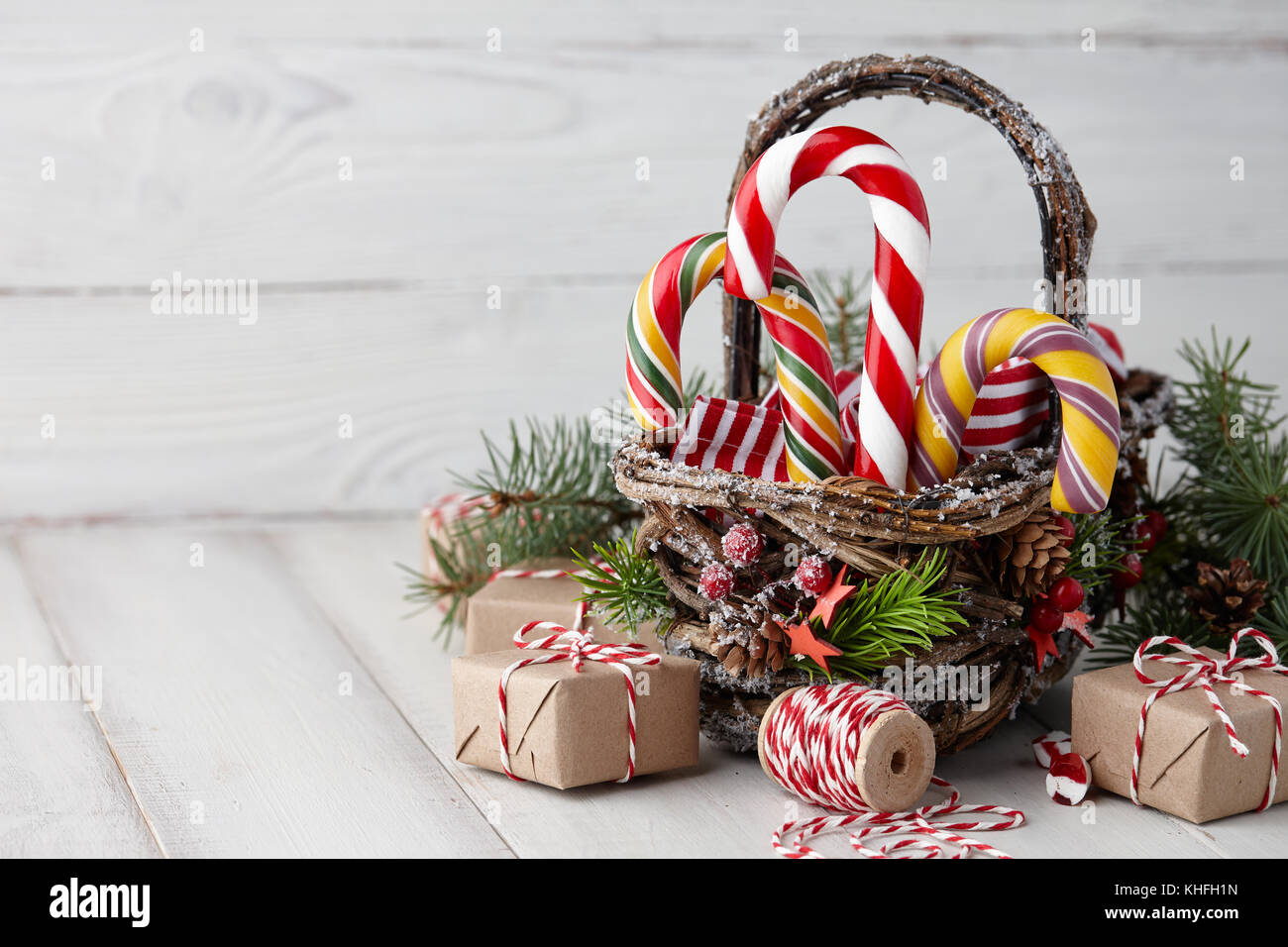 Christmas wicker basket with striped candy canes and wrapped gifts on