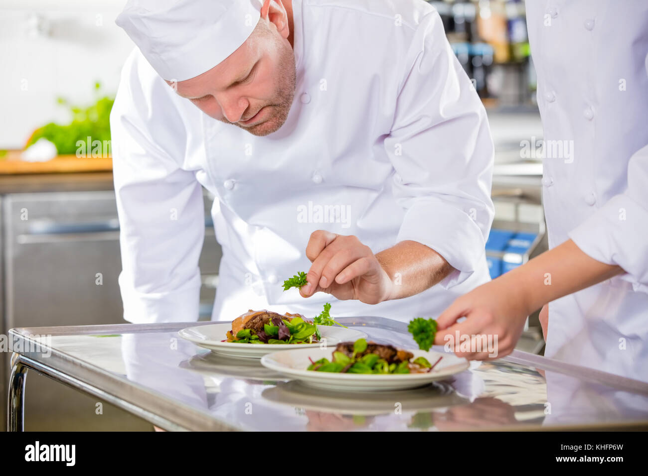 Two dedicated chefs prepares steak dish at gourmet restaurant Stock Photo