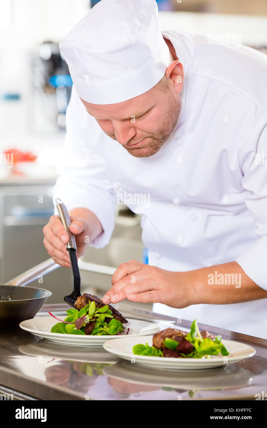 Chef prepares steak dish at gourmet restaurant Stock Photo