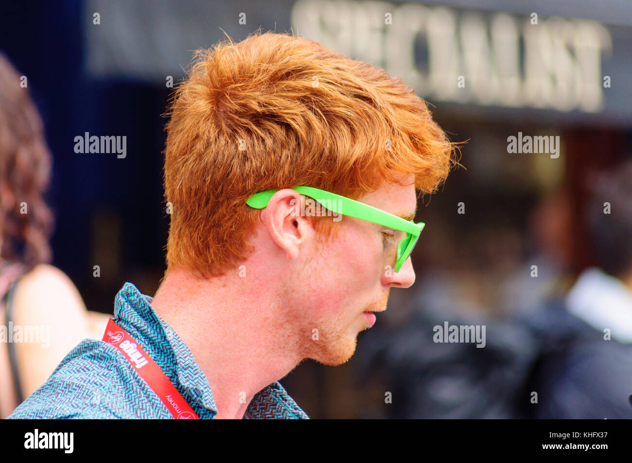 Male singer with red hair and wearing green sunglasses performing on the Royal Mile during the
